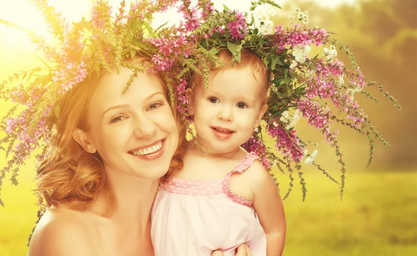 Happy laughing daughter hugging mother in wreaths of summer flow — Stock Photo, Image