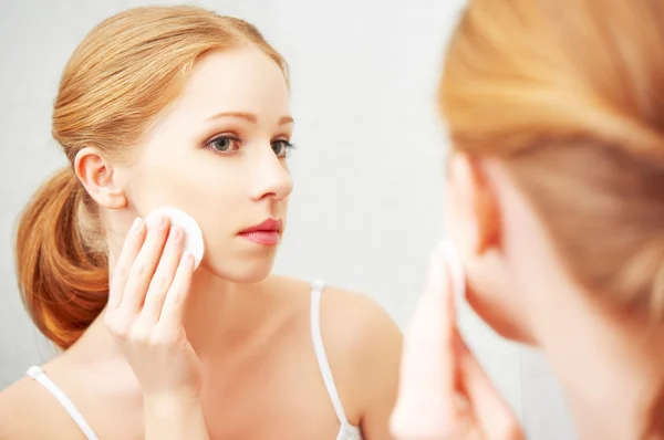 Vacker ung kvinna tar bort makeup med ansiktsvård — Stockfoto