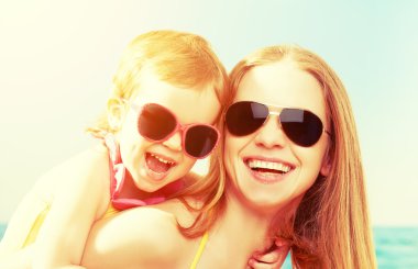 Sahilde mutlu bir aile. Anne ve bebek kız  