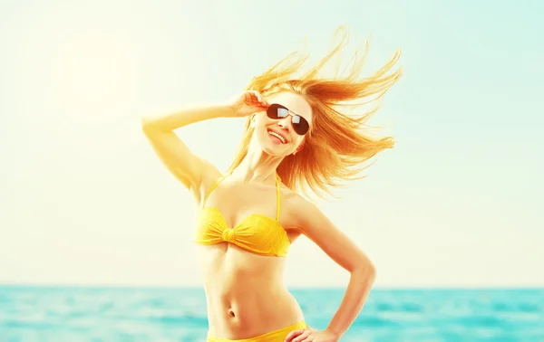 Beautiful young woman with hair flying in the wind and sunglasse — Stock Photo, Image