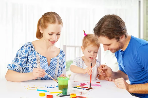 Счастливая семья: мать, отец и ребенок дочь рисовать краски — стоковое фото