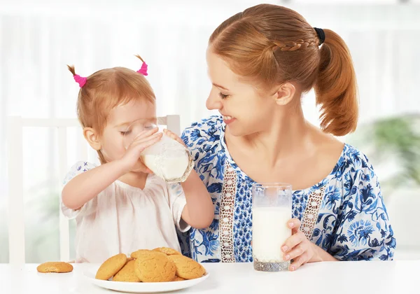 happy family mother and baby daughter girl at breakfast: biscuit