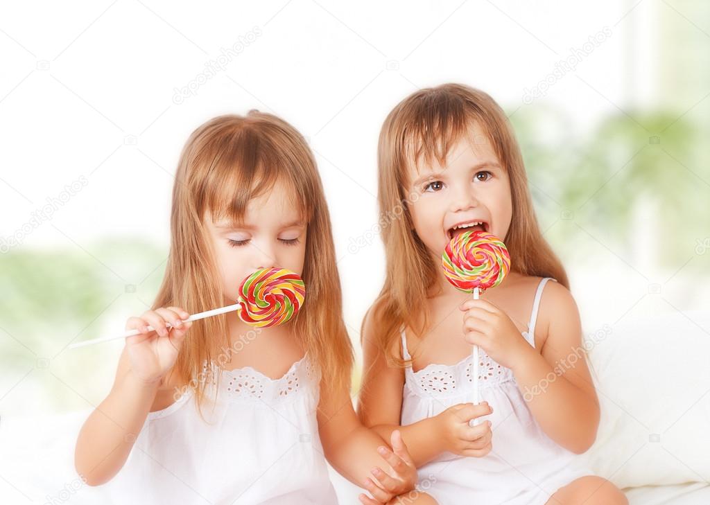 happy girl  twin sisters with lollipops candy