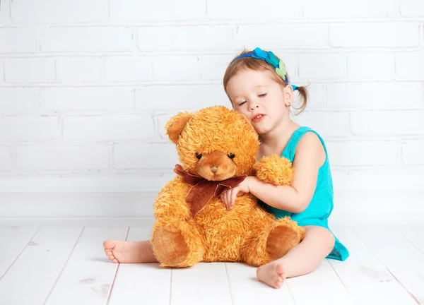 Meisje van de baby een geliefde teddy bear knuffelen — Stockfoto