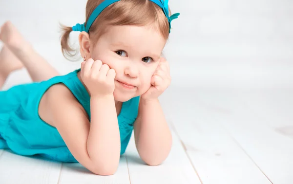 Mooie kleine babymeisje in een turquoise jurk — Stockfoto