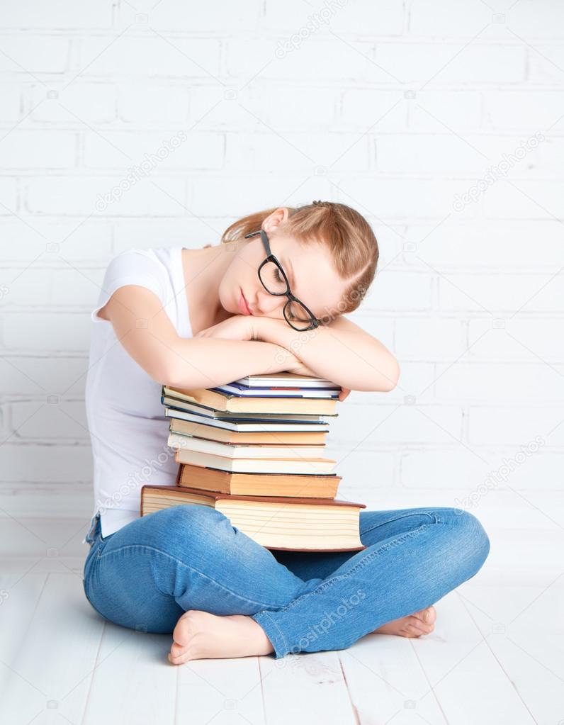 ired student girl asleep hugging books