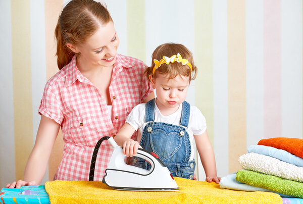 family mother and baby daughter together engaged in housework ir