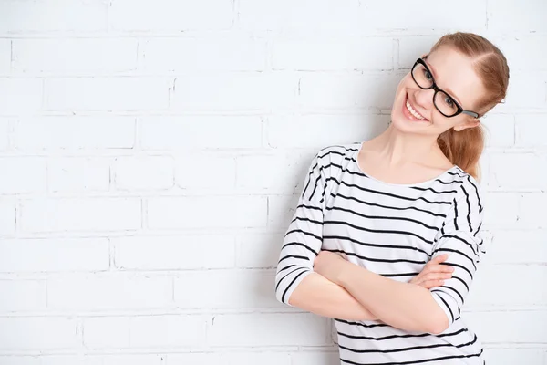 Glad tjej student i glas på en tom vit tegelvägg — Stockfoto