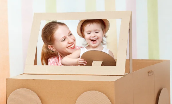 Glad familj mamma och lilla dotter rida på leksaksbil av — Stockfoto