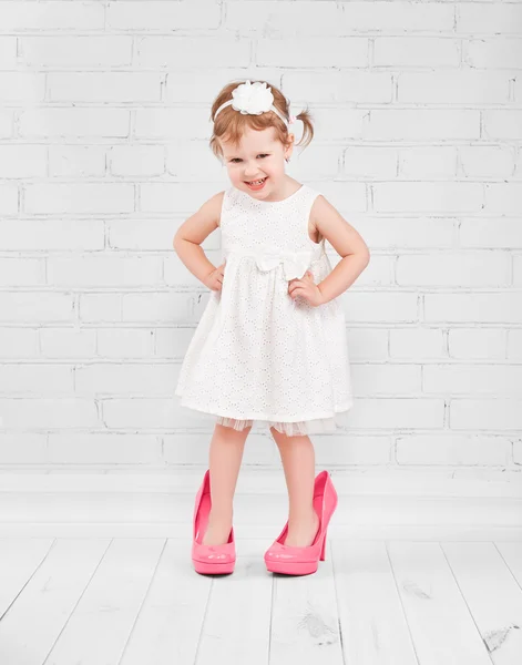 Bambina fashionista in grandi scarpe con tacco rosa — Foto Stock