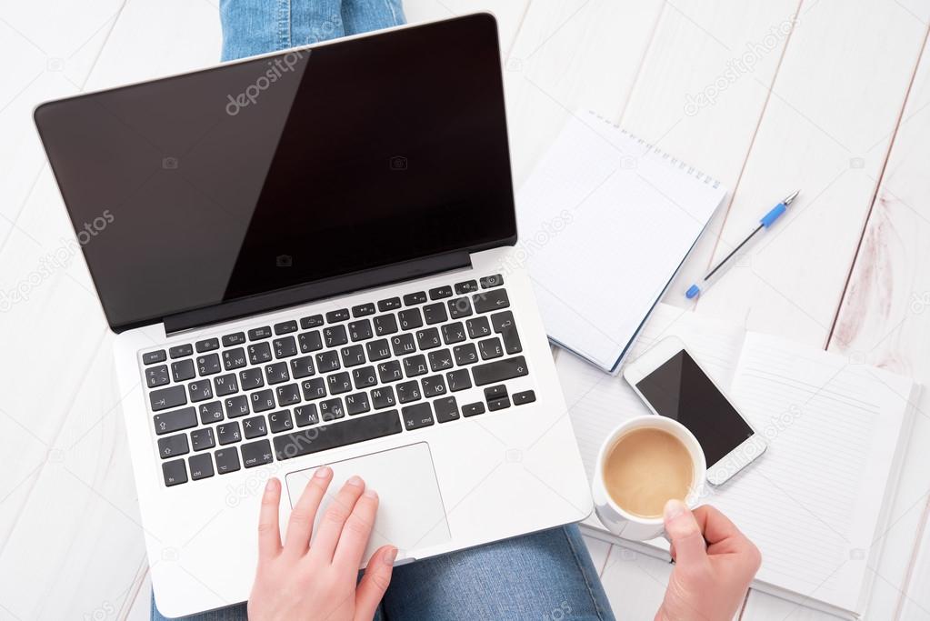 happy young woman  relaxes and  working at home at a laptop with