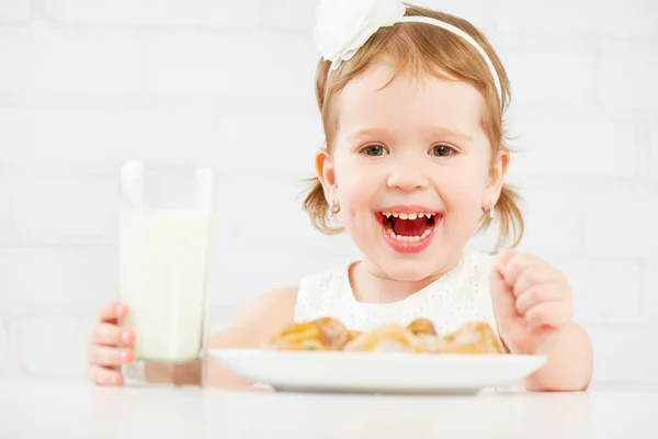 Ευτυχισμένος κορίτσι παιδί τρώει μπισκότα και γάλα — Φωτογραφία Αρχείου