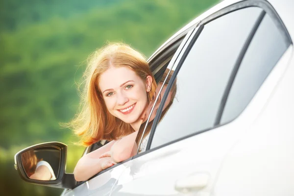 Gelukkige vrouw kijkt uit het raam van de auto op de natuur — Stockfoto