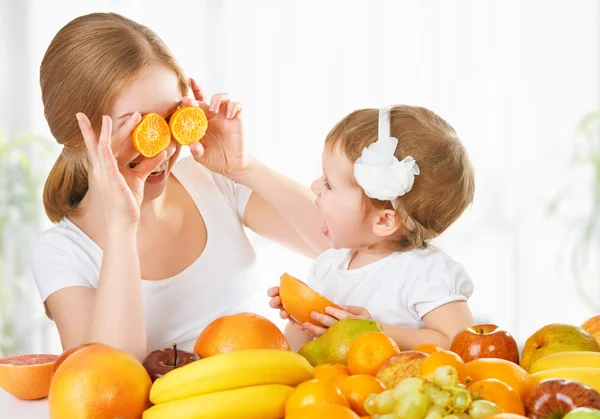 Família feliz mãe e filha menina, comer saudável vegeta — Fotografia de Stock