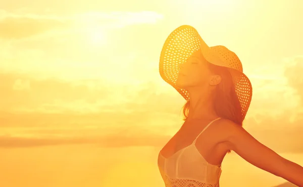 Mujer de belleza feliz en sombrero abrió las manos, disfruta de la puesta del sol sobre s —  Fotos de Stock