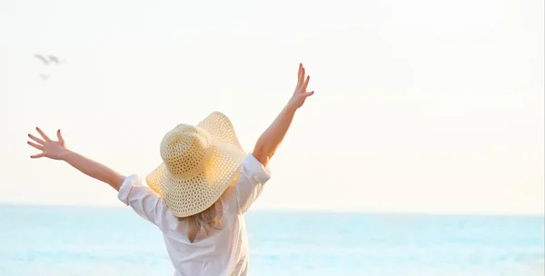 Happy woman standing arms outstretched back and enjoy life on be — Stock Photo, Image