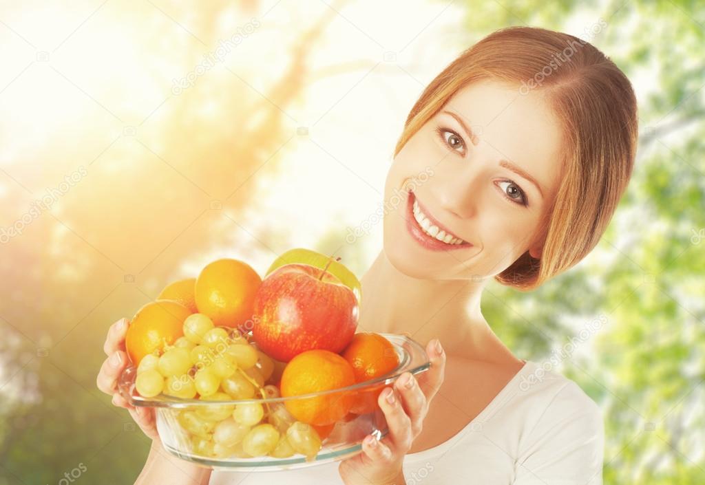 Healthy Eating. a woman with a plate of fruit in summer on natur
