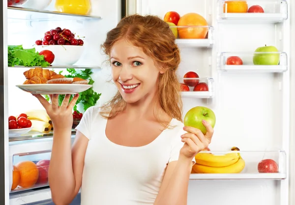 Mujer a dieta para elegir entre alimentos saludables y poco saludables cerca —  Fotos de Stock