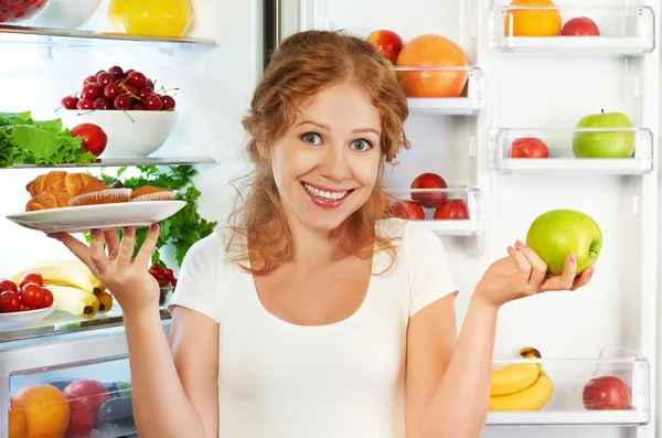 Femme sur le régime alimentaire à choisir entre des aliments sains et malsains près — Photo