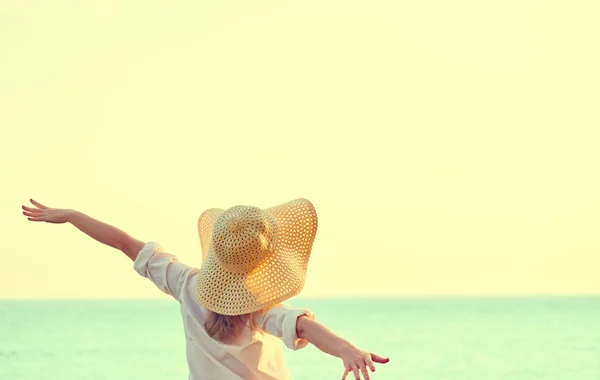 Happy woman in hat is back  opened his hands, enjoys sunset — Stock Photo, Image