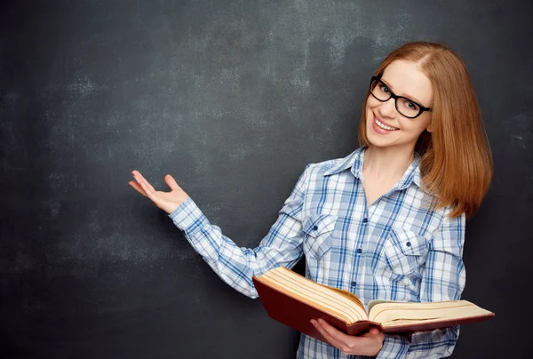 Happy girl student with glasses and book from blank blackboard — Stok fotoğraf