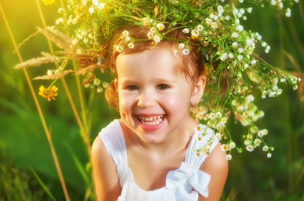 Divertente bambino felice ragazza in una ghirlanda sulla natura ridere in su — Foto Stock