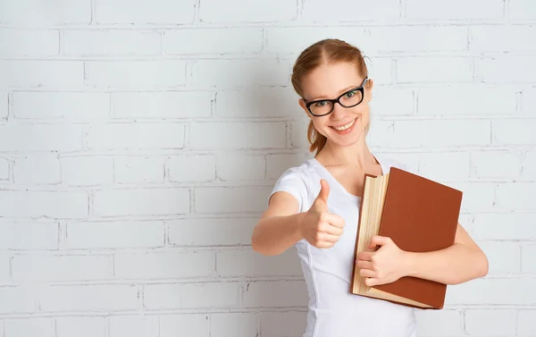 Menina estudante de sucesso feliz com livro mostrando polegares para cima — Fotografia de Stock