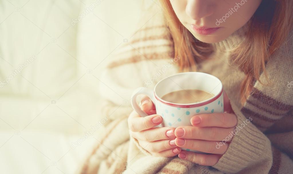 cup of hot coffee warming in the hands of a girl