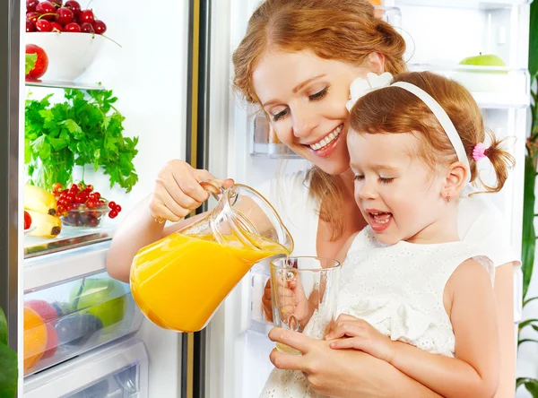 Felice famiglia madre e figlia beve succo d'arancia in — Foto Stock