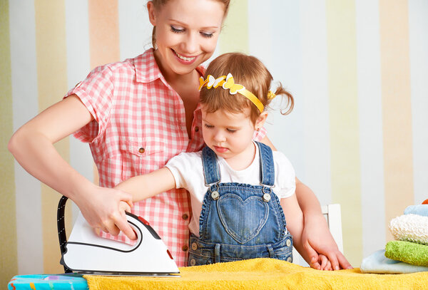 family mother and baby daughter together engaged in housework ir