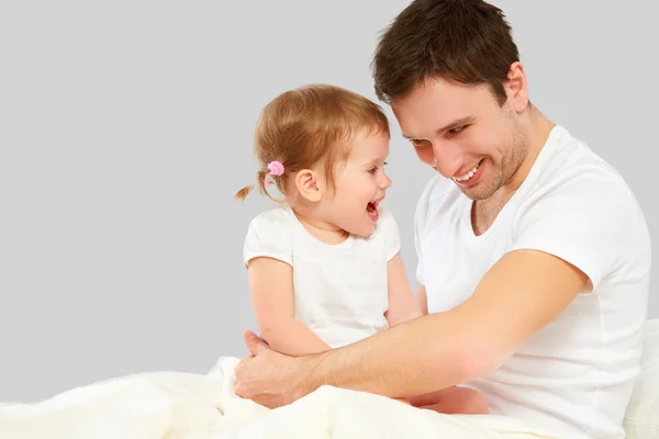 Feliz família pai e bebê filha brincando na cama — Fotografia de Stock