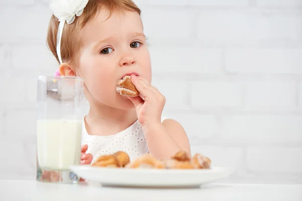 Bambino felice ragazza mangia biscotti e latte — Foto Stock