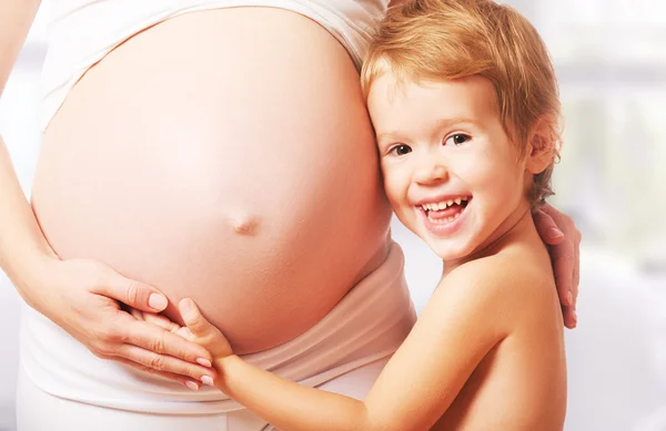 Glückliche Familie. Kind umarmt Bauch einer schwangeren Mutter — Stockfoto