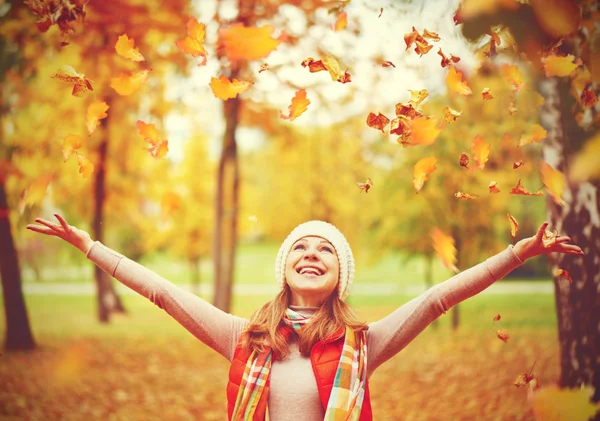 Happy girl throws up autumn leaves in park for walk outdoors — Stock Photo, Image