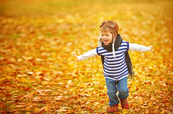 Glückliches Kind spielt Flieger im Herbst im Freien — Stockfoto