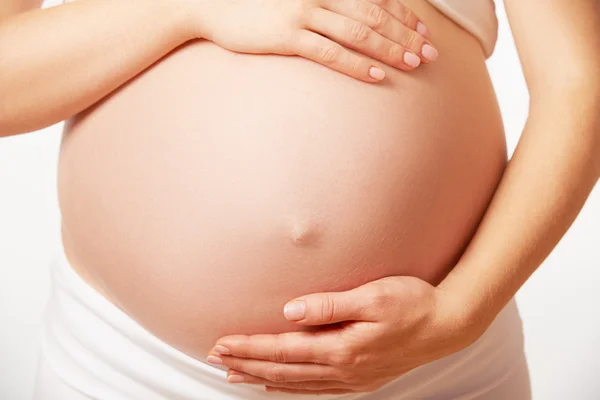 Belly magen av gravid kvinna på vit bakgrund — Stockfoto