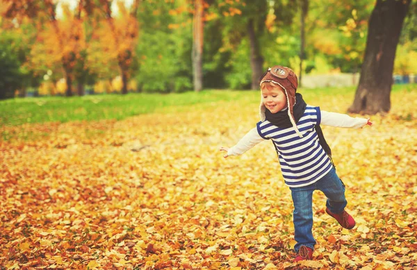 Criança feliz jogando piloto aviador ao ar livre no outono — Fotografia de Stock