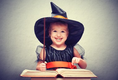 Cadılar Bayramı. sihirli değnek ve kitap conjur ile neşeli küçük cadı
