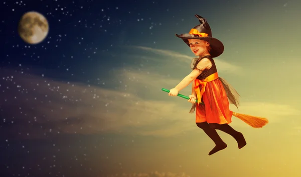 Halloween. Witch child flying on broomstick at sunset night sky. — Stock Photo, Image