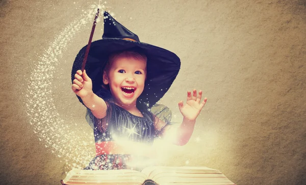 Halloween. cheerful little witch with a magic wand and glowing b — Stock Photo, Image