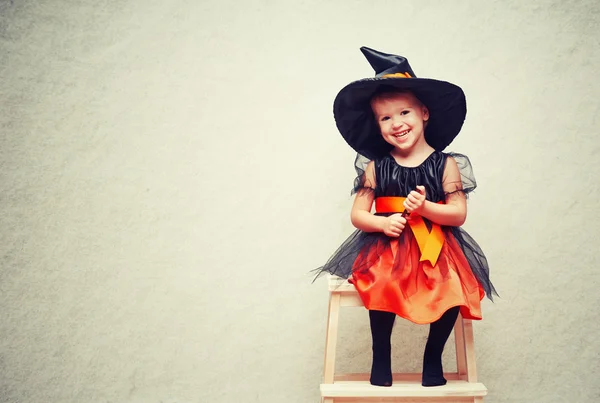 Halloween. fröhliche kleine Hexe mit einem Zauber. — Stockfoto