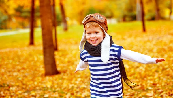 Щаслива дитина грає пілотного авіатора на відкритому повітрі восени — стокове фото