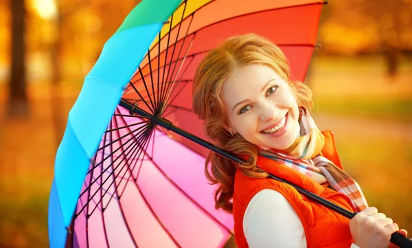 Mujer feliz con paraguas multicolor arco iris bajo la lluvia a la par —  Fotos de Stock