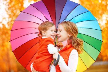 Umbrell mutlu aile anne ve çocuk kızı ile gökkuşağı renkli
