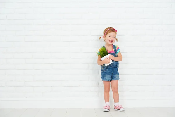 Gelukkig kind meisje lachen en die pot met ingegoten plant in de buurt van — Stockfoto