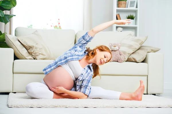 Pregnant woman practicing yoga and fitness at home — Stock Photo, Image