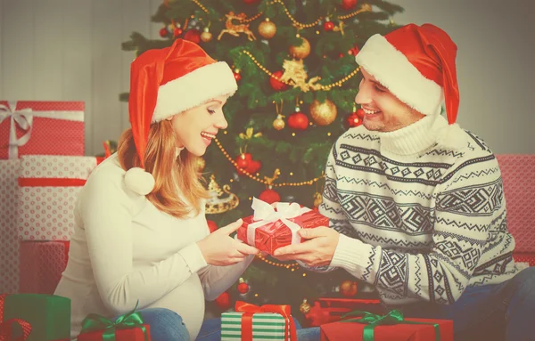 Feliz pareja familiar con un regalo en Navidad en casa — Foto de Stock