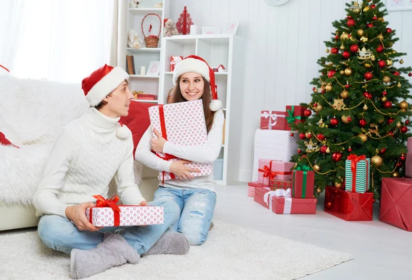 Счастливая семейная пара с подарком на Рождество дома — стоковое фото