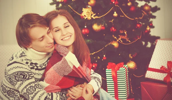 Θερμαίνεται ευτυχισμένο ζευγάρι ερωτευμένων στη αγκαλιά στο χριστουγεννιάτικο δέντρο — Φωτογραφία Αρχείου