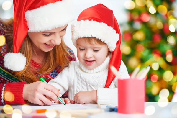 Счастливая семья мать и дочь написать письмо Санта-о — стоковое фото
